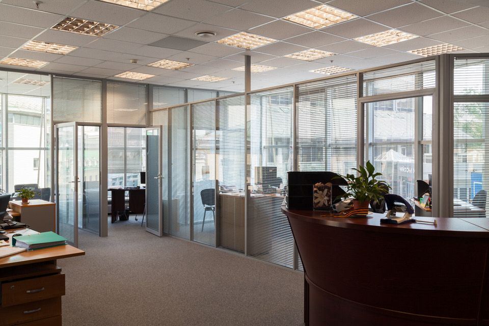 Общий вид офиса со стеклянными перегородками и жалюзи