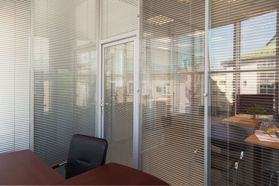 Переговорная зона за стеклянной перегородкой с жалюзи в офисе Anotech