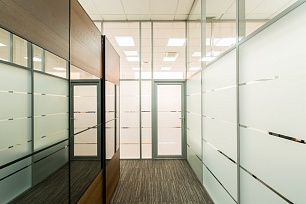 Коридор офиса с перегородками из стекла и матовыми полосами на панелях