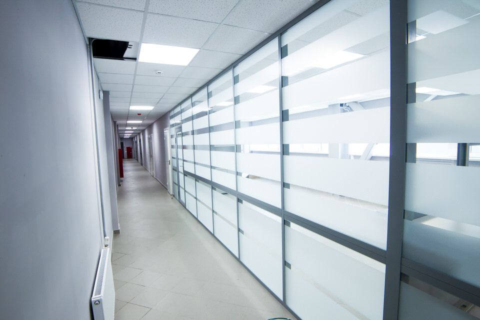 Офисный коридор со стеклянными перегородками и матовыми полосами