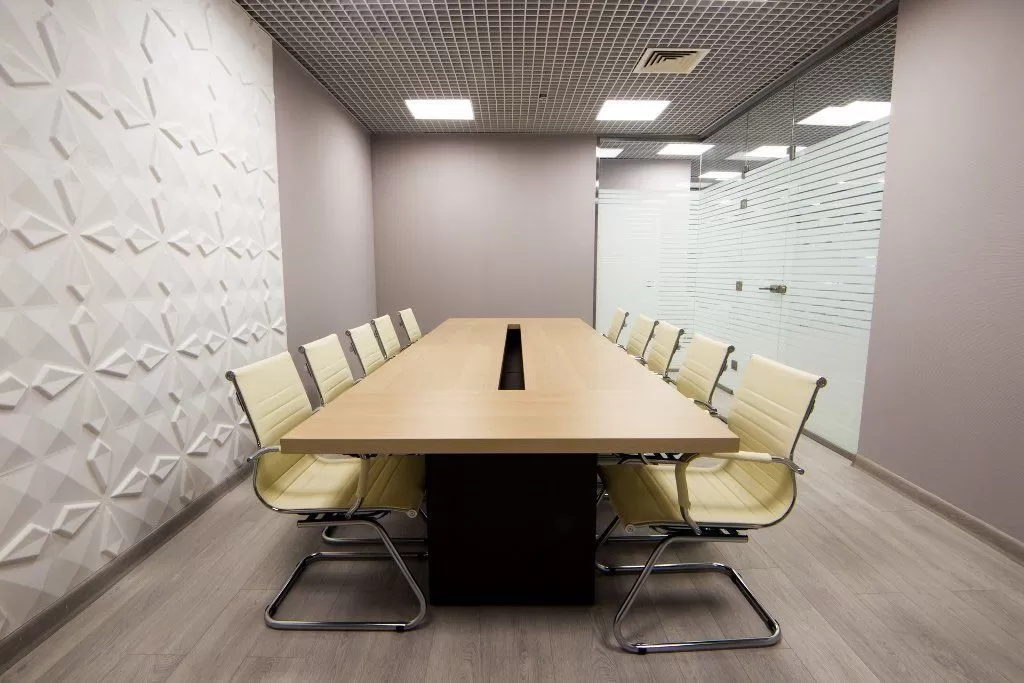 Переговорная комната с длинным столом и стеклянной перегородкой с матовыми полосами