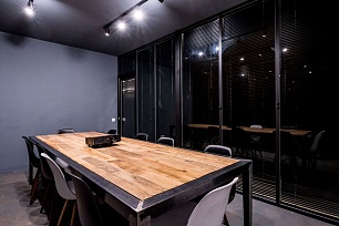 Переговорная с длинным столом за стеклянной перегородкой в черном профиле