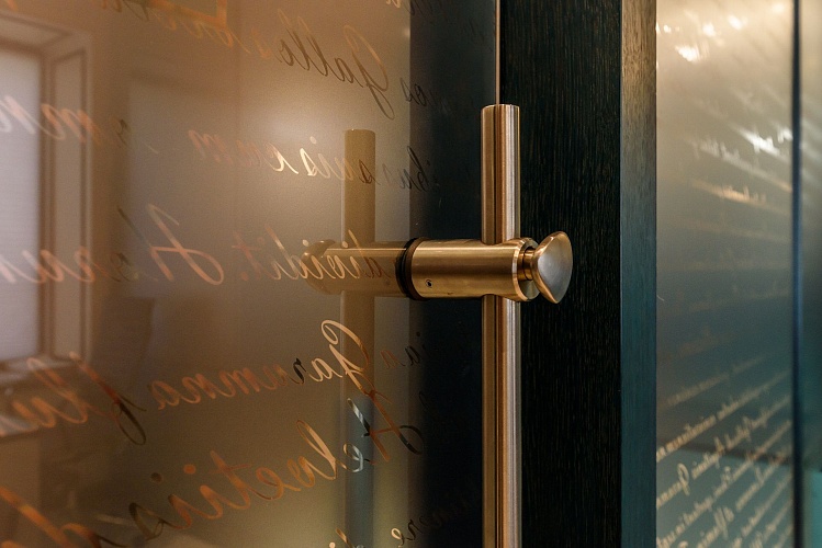 Ручка-скоба из нержавеющей стали на стеклянной двери — крупный план