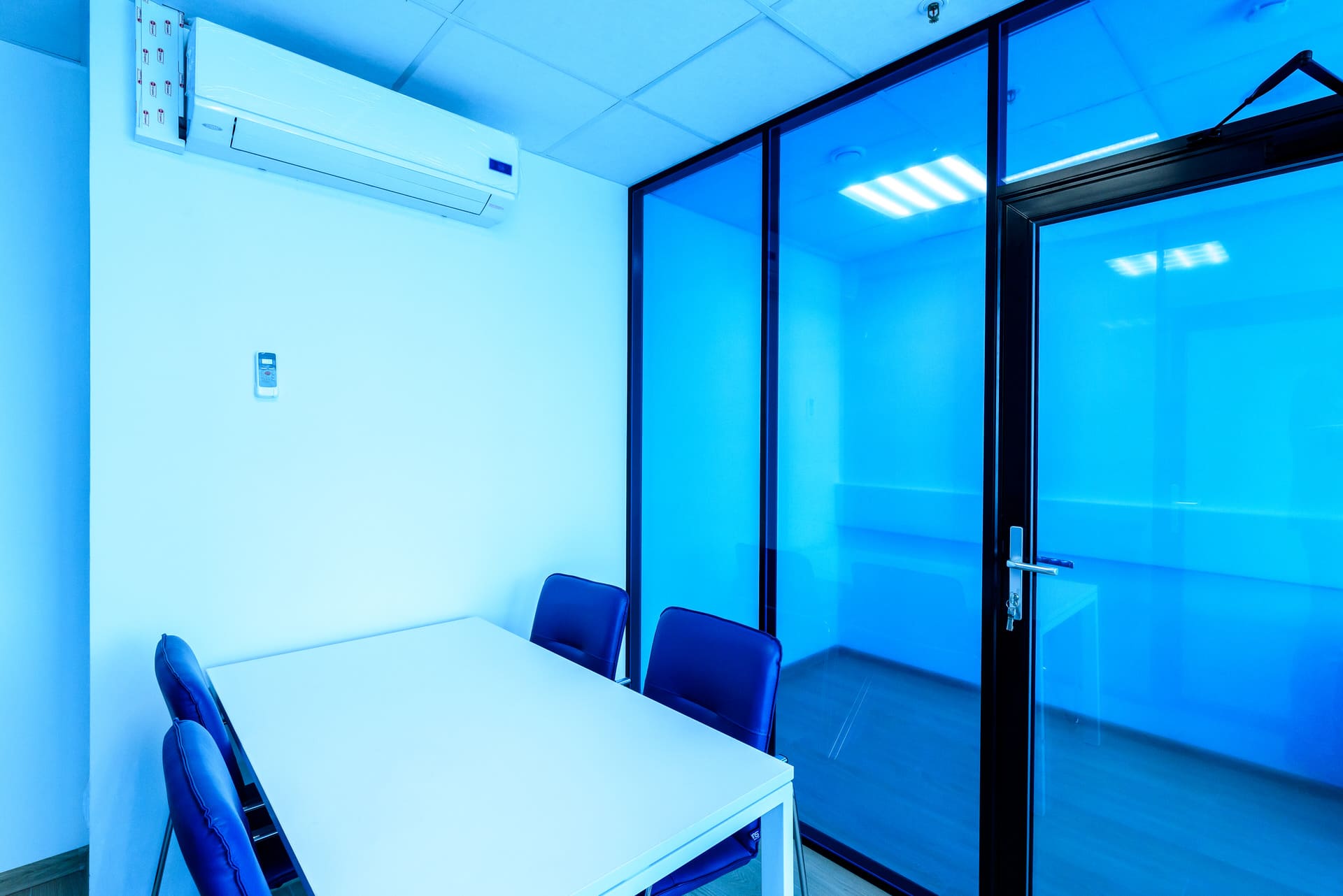 Синяя стеклянная перегородка с дверью в переговорной комнате