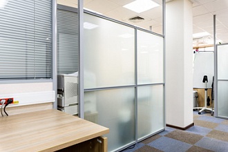 Каркасная стеклянная перегородка с жалюзи в офисе