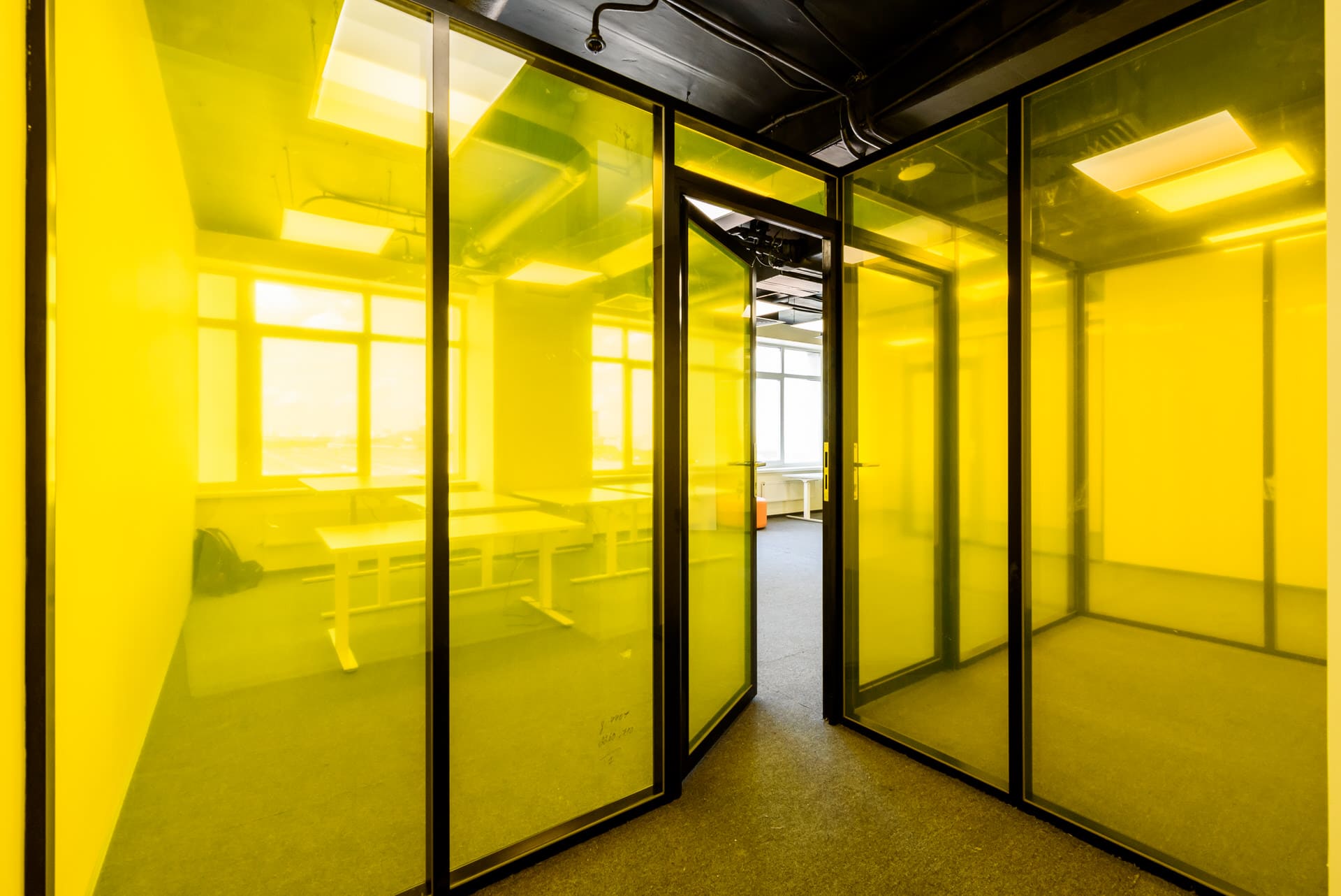 Вид изнутри через желтые стеклянные перегородки и дверь